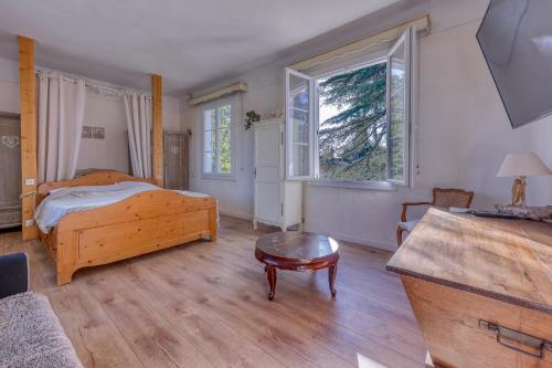 une chambre avec un lit et une table et deux fenêtres dans l'établissement La Tartane - Maison climatisée proche plage, à Toulon