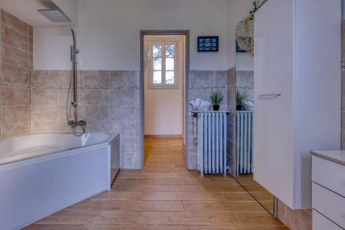 La salle de bains est pourvue d'une baignoire et de parquet. dans l'établissement La Tartane - Maison climatisée proche plage, à Toulon