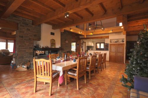 een eetkamer met een tafel en stoelen en een kerstboom bij Chez Maguy Chambres d'hôtes in Les Angles