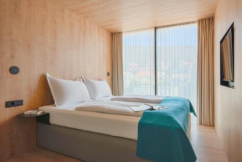 a bedroom with a bed with a large window at Hotel Katarina in Selce