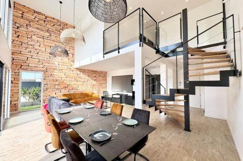 une salle à manger avec une table et un mur de briques dans l'établissement Luxury ! Villa de standing Piscine Plages à pied, à Riantec