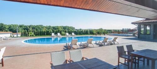 a patio with chairs and a swimming pool with a table at Villa Trakia in Simeonovo