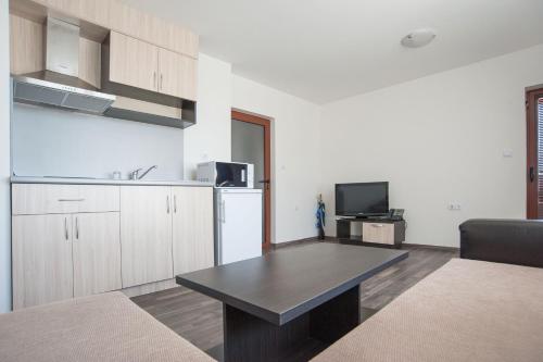a living room with a table and a kitchen at Villa Trakia in Simeonovo