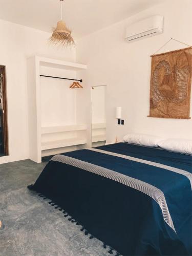 a bedroom with a bed with a blue blanket on it at Casa Ohma La Punta in Brisas de Zicatela