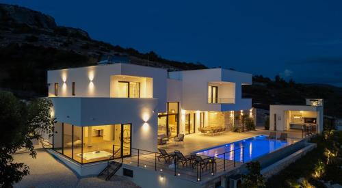 una grande casa bianca con piscina di notte di Luxury, seaview Villa Grandeca a Rogoznica (Rogosnizza)
