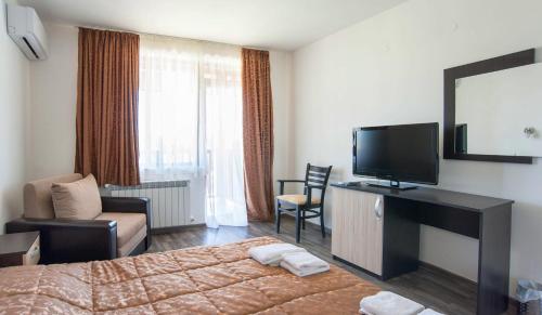 a hotel room with a bed and a flat screen tv at Villa Trakia in Simeonovo