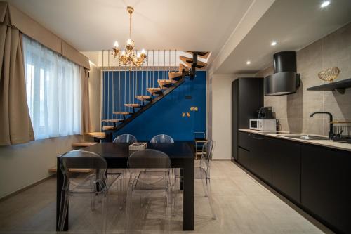 a kitchen and dining room with a table and a staircase at Napoleon Suites & Apartments in Susa