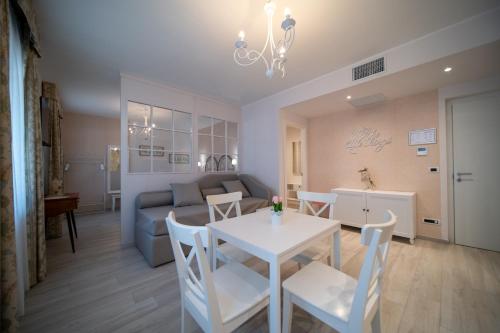 a living room with a couch and a table and chairs at Napoleon Suites & Apartments in Susa