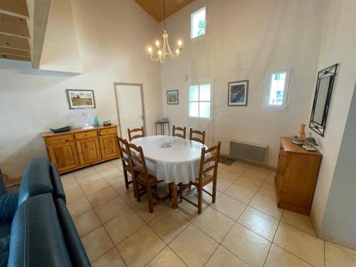 une salle à manger avec une table et un canapé dans l'établissement Villa proche forêt et plage à La Tranche-sur-Mer - FR-1-22-381, à La Tranche-sur-Mer