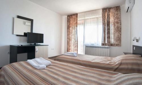 a hotel room with two beds and a television at Villa Trakia in Simeonovo