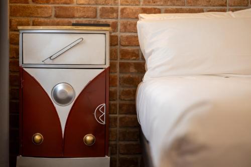 a bed and a clock next to a bed at Napoleon Suites & Apartments in Susa
