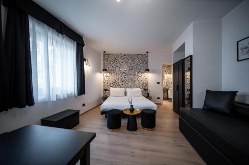 a hotel room with a bed and a couch at Napoleon Suites & Apartments in Susa