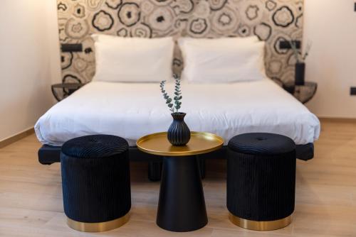 a bedroom with a bed with a vase on a table at Napoleon Suites & Apartments in Susa