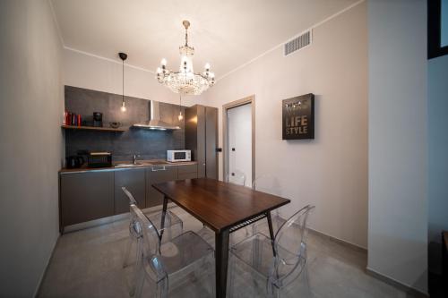 a kitchen with a table and chairs and a chandelier at Napoleon Suites & Apartments in Susa