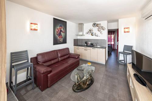 un salon avec un canapé et une table et une cuisine dans l'établissement Appartement POMME D'AMOUR Port Nature PN423 - Luxe - 2 personnes, au Cap d'Agde