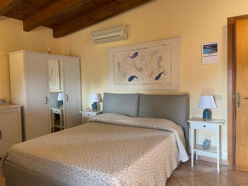 a bedroom with a bed and two tables with lamps at Vento di Grecale in Favignana
