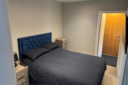 ein Schlafzimmer mit einem blauen Bett und einer Holztür in der Unterkunft Cozy Apartment in Stoke-on-Trent One double bed in Stoke on Trent
