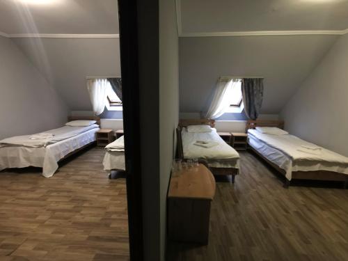 a room with two beds and two windows at Хостел-готель Кремзлик in Yasinya