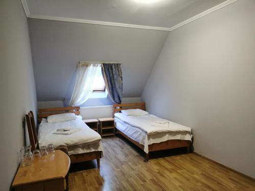 a room with two beds and a table and a window at Хостел-готель Кремзлик in Yasinya