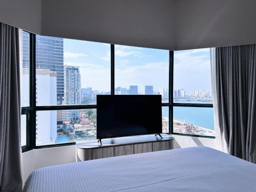 a hotel room with a bed and a large window at Ascott Gurney Penang in George Town