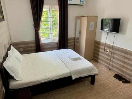 - une chambre avec un lit, une télévision et une fenêtre dans l'établissement Trường Ân Homestay, à Hue