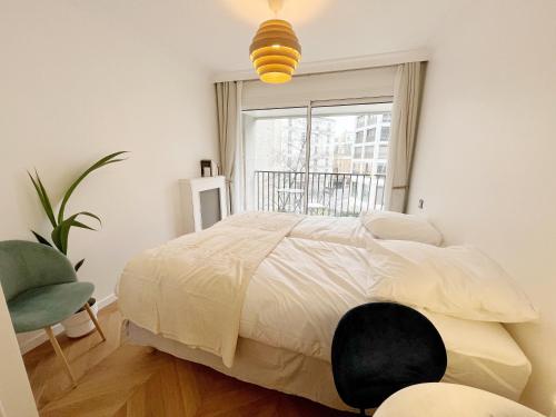 une chambre avec un grand lit et une fenêtre dans l'établissement Denfert Rochereau -Cozy and pleasant stay with terrace, à Paris