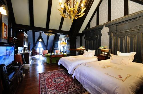 a bedroom with two beds and a flat screen tv at The Old England Manor in Renai