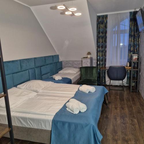 a bedroom with two beds with towels on them at Jarzębinowy Resort & SPA in Braniewo