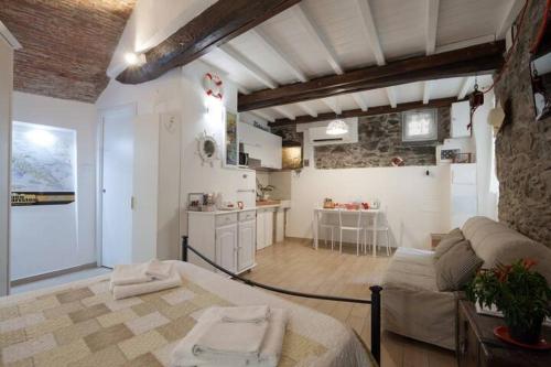 ein Wohnzimmer mit Couch und Küche in der Unterkunft Rio Alba red loft - holiday house - Riomaggiore 5terre in Riomaggiore
