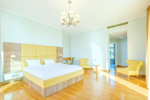 a bedroom with a large bed and two chairs at Castello Mare Hotel in K'obulet'i
