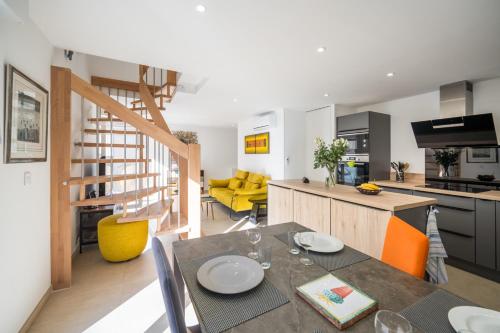 Il comprend une cuisine et un salon avec une table à manger. dans l'établissement Les Voiles d Azur, Duplex moderne avec vue sur le port et la mer, à 2 minutes des plages, à Vallauris