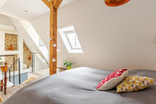 une chambre avec un lit avec deux oreillers dessus dans l'établissement Superbe duplex prox centre-ville Beautiful duplex close to center, à Strasbourg