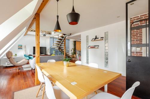 une salle à manger avec une table en bois et des chaises blanches dans l'établissement Superbe duplex prox centre-ville Beautiful duplex close to center, à Strasbourg