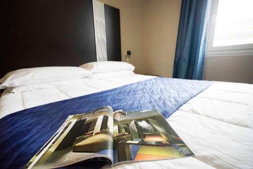 a bedroom with a bed with a book on it at Hotel Principe in Casale Monferrato