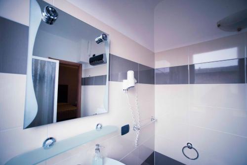a bathroom with a mirror and a sink at Hotel Principe in Casale Monferrato