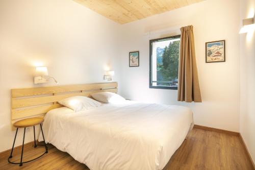 a bedroom with a large white bed and a window at VVF Les 7 Laux Massif de Belledonne in Prapoutel