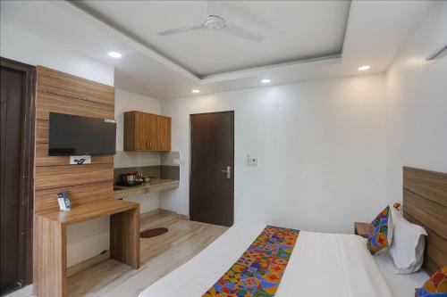 a bedroom with a bed and a desk and a tv at FabHotel Unique Stay in Noida