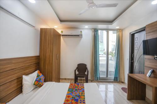 a bedroom with a bed and a desk and a television at FabHotel Unique Stay in Noida