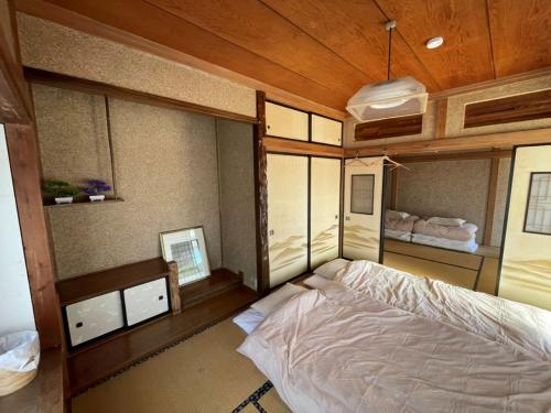 Ein Bett oder Betten in einem Zimmer der Unterkunft 古民家宿Tabi湊