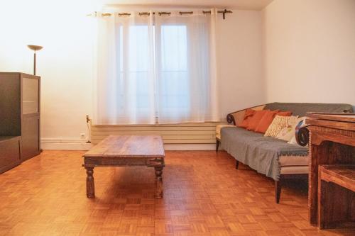 Una sala de estar con un sofá y una mesa de café. en 2 bedrooms 60m2 near RER A, en Joinville-le-Pont