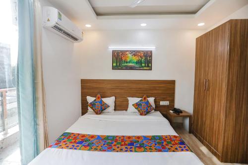 a bedroom with a bed with a wooden headboard at FabHotel Unique Stay in Noida