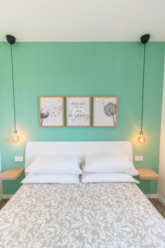 a bedroom with a bed with four pictures on the wall at Casa Irene in Loreto