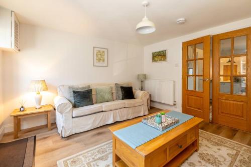 a living room with a couch and a table at 7 Prospect Place - Aldeburgh Coastal Cottages in Leiston