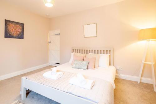 a bedroom with a white bed with two pillows at 7 Prospect Place - Aldeburgh Coastal Cottages in Leiston