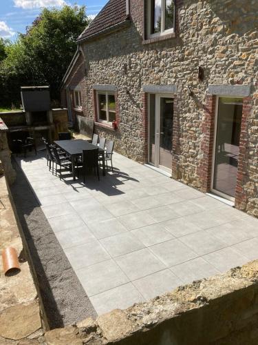 a patio with a table and chairs next to a building at Gite Al'Pampa in Fosses-La-Ville