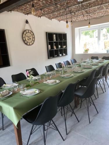 a room with a long table with chairs and a clock at Gite Al'Pampa in Fosses-La-Ville