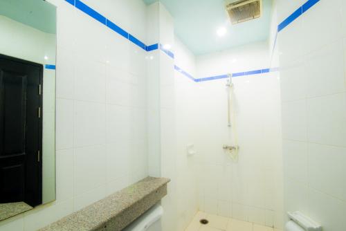 Baño blanco con aseo y espejo en DE Apartment, en Pattaya South