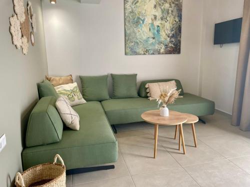 a living room with a green couch and a table at YANNIS RETREAT in Lefkada Town