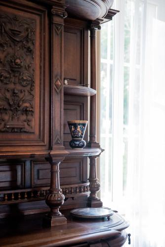 une armoire en bois avec un vase posé sur une table dans l'établissement Domaine de Gondal, demeure de charme, à Palaja