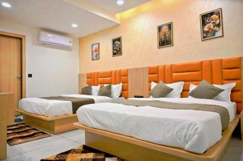 two beds in a hotel room with two bedsvisor at Hotel Sky Gold in Ahmedabad